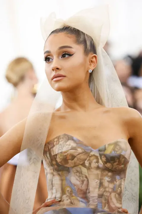 Ariana Grande in sleeveless dress and white head bow