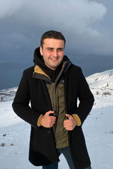 Burak Özdemir wearing black jacket. He is enjoying at snow.