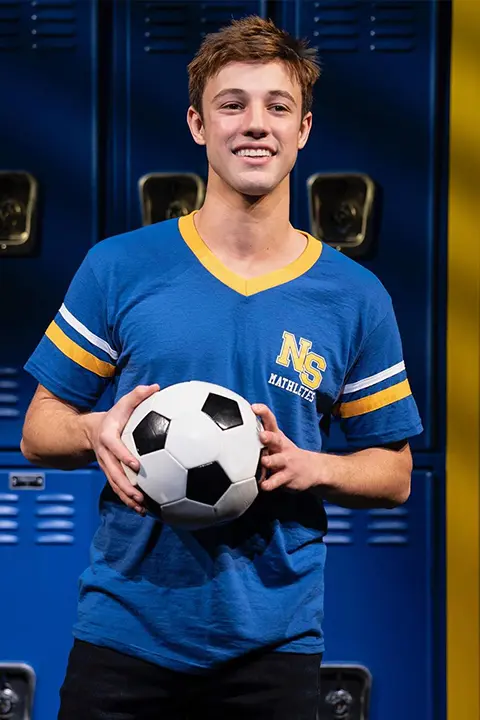 Cameron Dallas in blue shirt and football in his hands