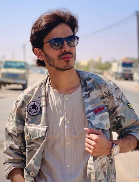 Farhan Khan wearing army style jacket and black glasses with rolex watch. He is looking handsome in his stubble