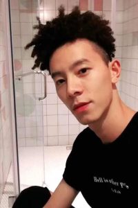 Jin Jun in bathroom, wearing black t shirt