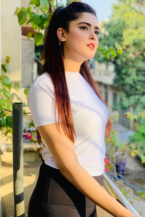 Kanwal Aftab at her home's balcony wearing white sleeveless shirt and black trousers