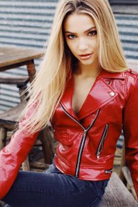 Liza J model in red leather jacket. Looking flirtatiously at camera