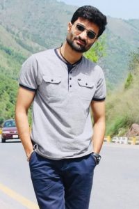 Mansoor Kazmi in grey t shirt and blue pants in mountains