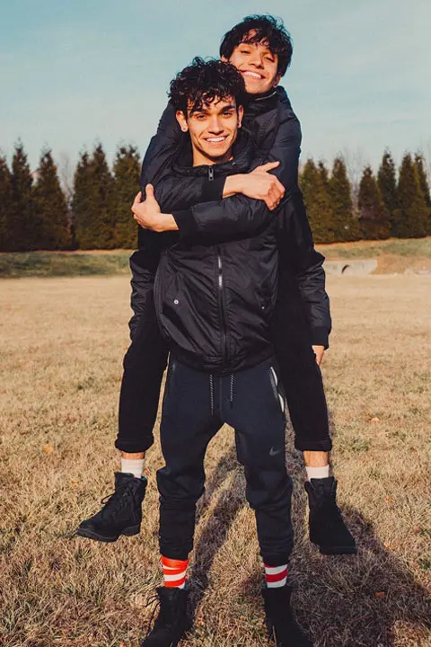 The Dobre Twin wearing all black and looking cute while hoping over each other.