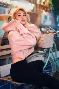 Wengie Jie wearing pink jacket and black skinny jeans with her belly exposed