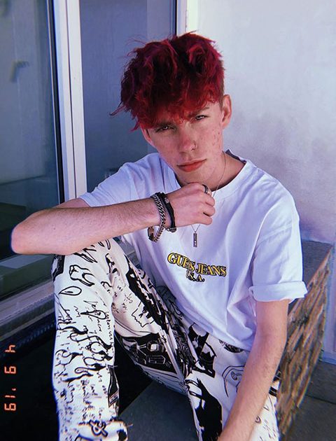 Zephan clark with red hair, white shirt and bold bracelets