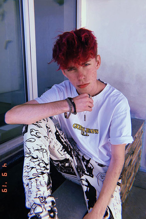 Zephan clark with red hair, white shirt and bold bracelets