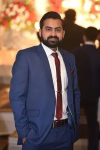 Uzair ul haq is wearing blue suit and red tie