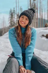 Aashna Hegde wearing blue jersey , black pent and black cap. Enjoying her vacations in snow