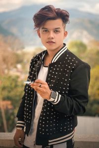 famous Indian Tiktok Star Riyaz Aly wearing a spiked black jacket and rocking his purple shade on hair