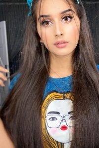 Alishba Anjum wearing blue tshirt and posing at camera with her brown eyes