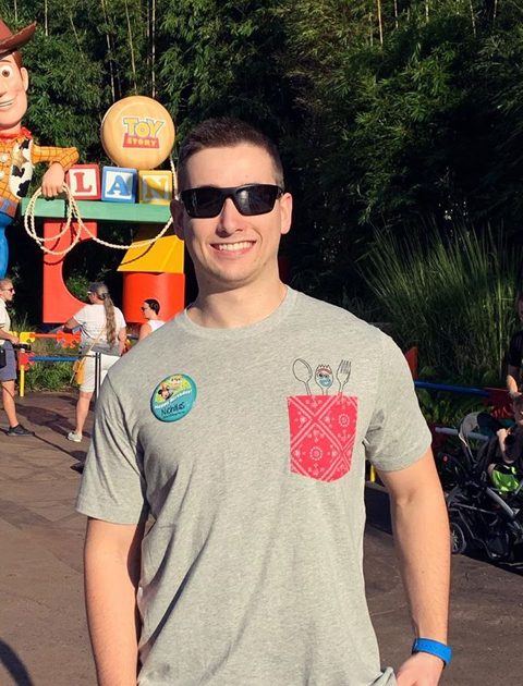 Nick Smithyman wearing grey tshirt and black sun glasses at amusement park