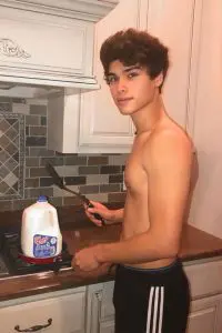 Alan Stokes shirtless in kitchen. He is showing his perfect muscular body and is frying a milk bottle