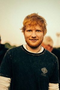 Ed Sheeran being causal, cool and smiling at camera.