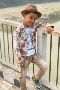famous Indian Tiktok Star Sadim Khan being stylish and dashing with his flower coat and brown hat. He is posing on bridge