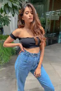 Indian Tiktok Star Unnati Malharkar wearing black sleeveless top and blue jeans and owning her curvy body.