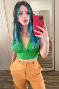 Bella Thorne is Green top and orange jeans.