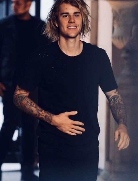 Justin Bieber is giving smile and wearing full black dress