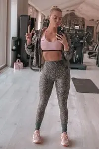 Khloe Kardashian wearing pink sports bra and dark grey pajama