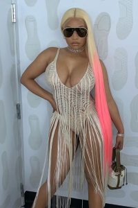 Nicki Minaj is wearing white net suit and holding a bag