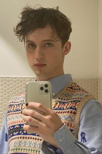 Troye Sivan taking selfie in blue shirt and sweater