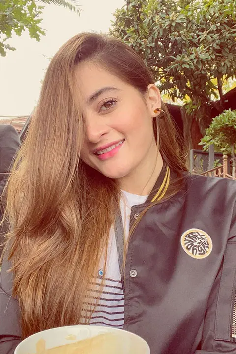 Aimen Khan with blonde hair and black jacket