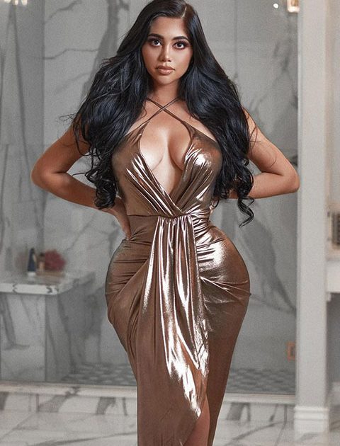 Jailyne Ojeda is posing for a picture and looking beautiful in open hair and golden dress.