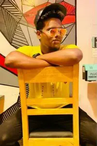 Indian Tiktok Star Harry D cruz seating on chair in yellow tshirt