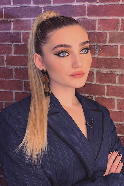 Meg Donnelly posing for picture in navy blue coat