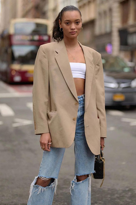 Lameka Fox in denim jeans and brown coat