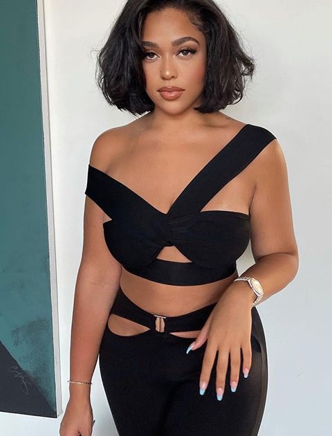 Jordyn Woods is beautifully posing for a picture in black dress.