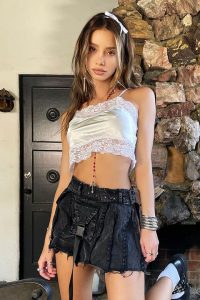 Kaile Goh in white laced top and black skirt